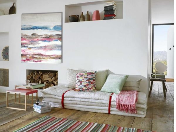 A romantic living room with a painting, soft colors, and cozy furniture.