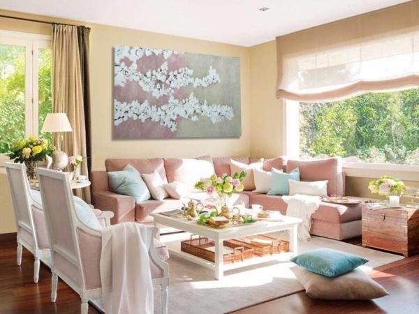A romantic living room with a painting, soft colors, and cozy furniture.