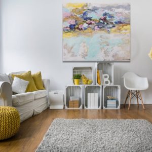 A romantic living room with a painting, soft colors, and cozy furniture.