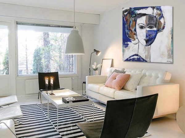 Neutral abstract paintings over a minimalist sofa.