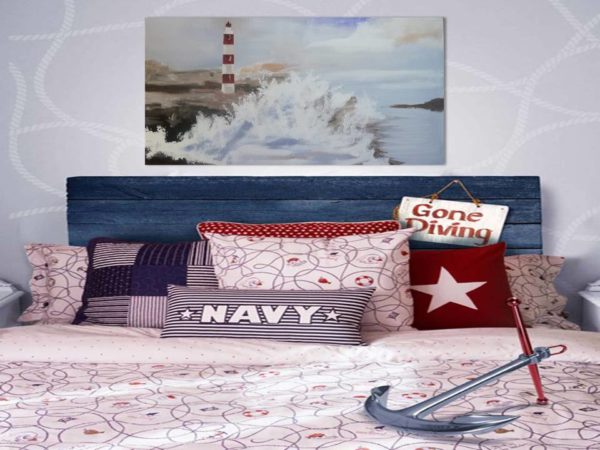 Nautical-themed bedroom with a lighthouse painting and "Gone Diving" sign.