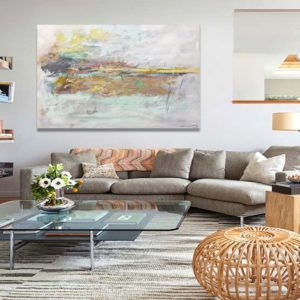 Gold abstract painting above white sofa in a bright modern living room.