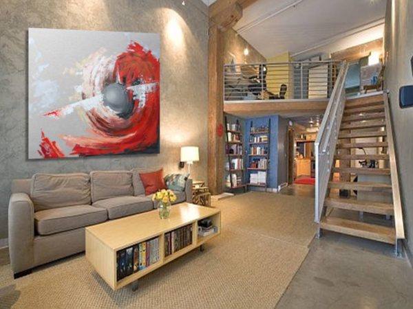 Red, grey, and black abstract painting in a modern loft setting.