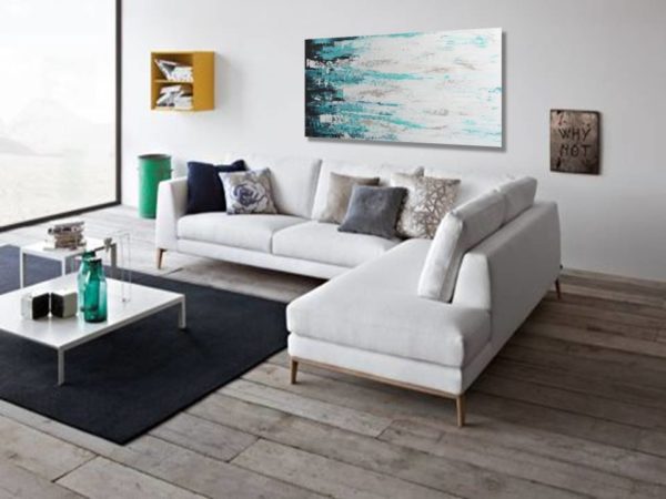 Modern living room with a white sectional and abstract teal art.