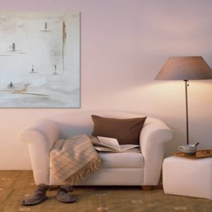Cozy reading nook with abstract figurative art and a white armchair.