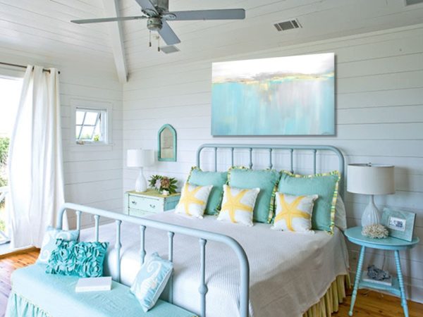 Turquoise painting with fish in a beach vibe bedroom decor.
