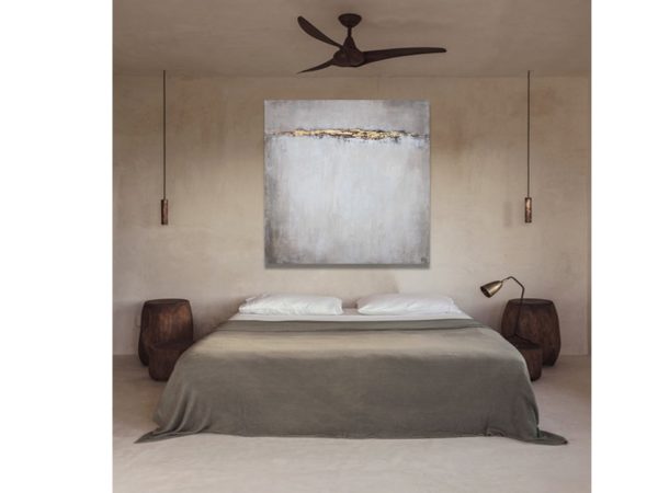 Minimalist bedroom with abstract beige painting and cactus decor.