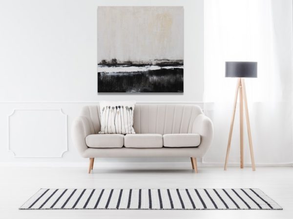 Minimalist black and beige landscape art above a light gray sofa.
