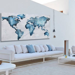 Blue watercolor world map art above a Paola Lenti Canvas sofa.