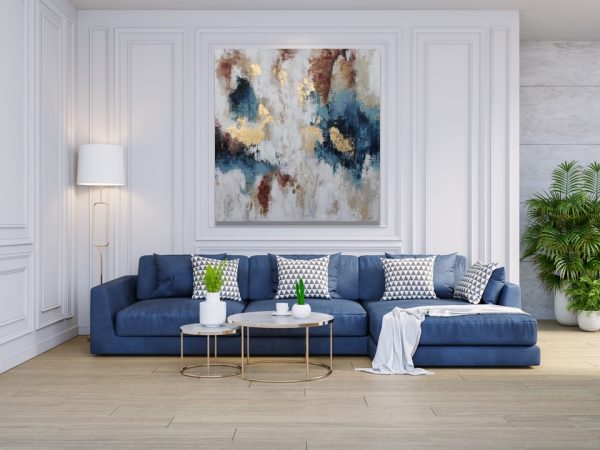 Art abstrait coloré au-dessus d'un canapé d'angle bleu.